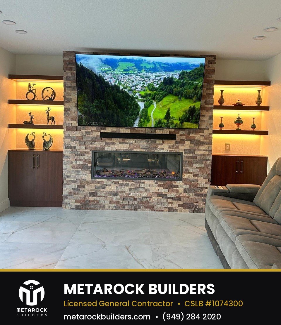 Fireplace remodel in Orange County by Metarock Builders, completed after photo with stacked stone surround, floating walnut shelves, and linear electric fireplace