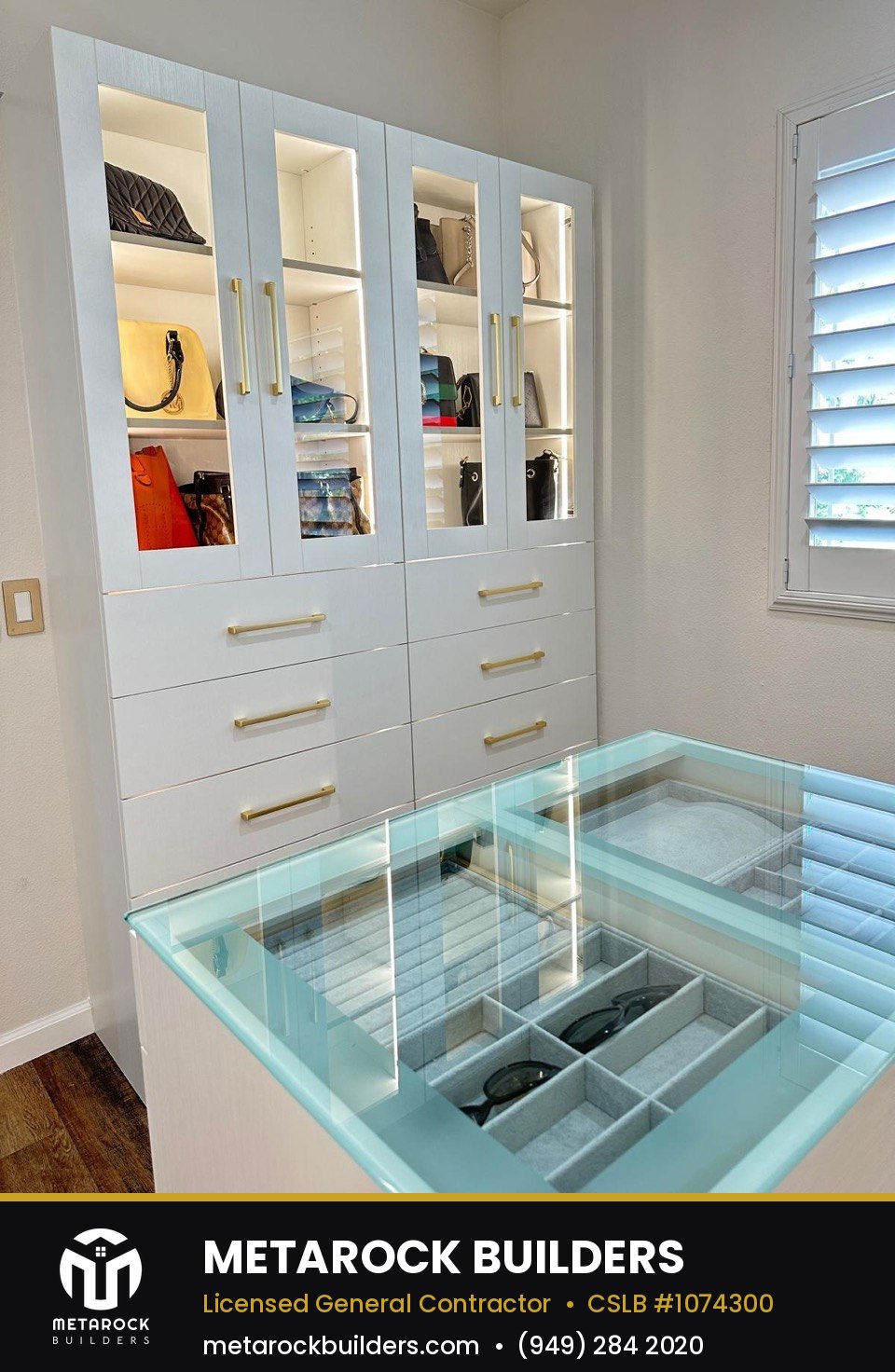 Closet remodel in Orange County by Metarock Builders, completed after photo with glass-front cabinetry, brushed brass hardware, and glass-top accessory display