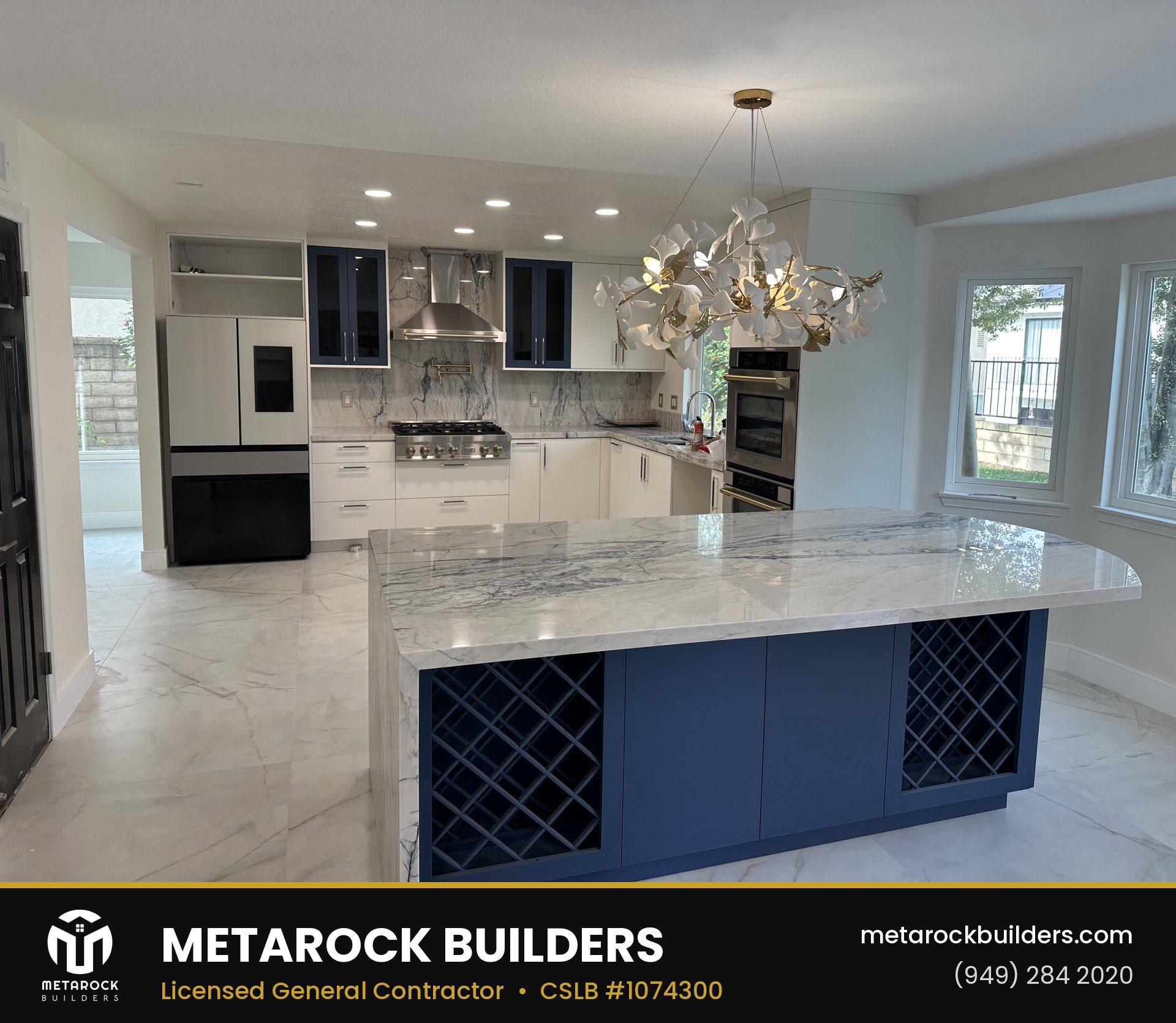 Kitchen remodel in Orange County by Metarock Builders, completed after photo with marble island and navy cabinetry