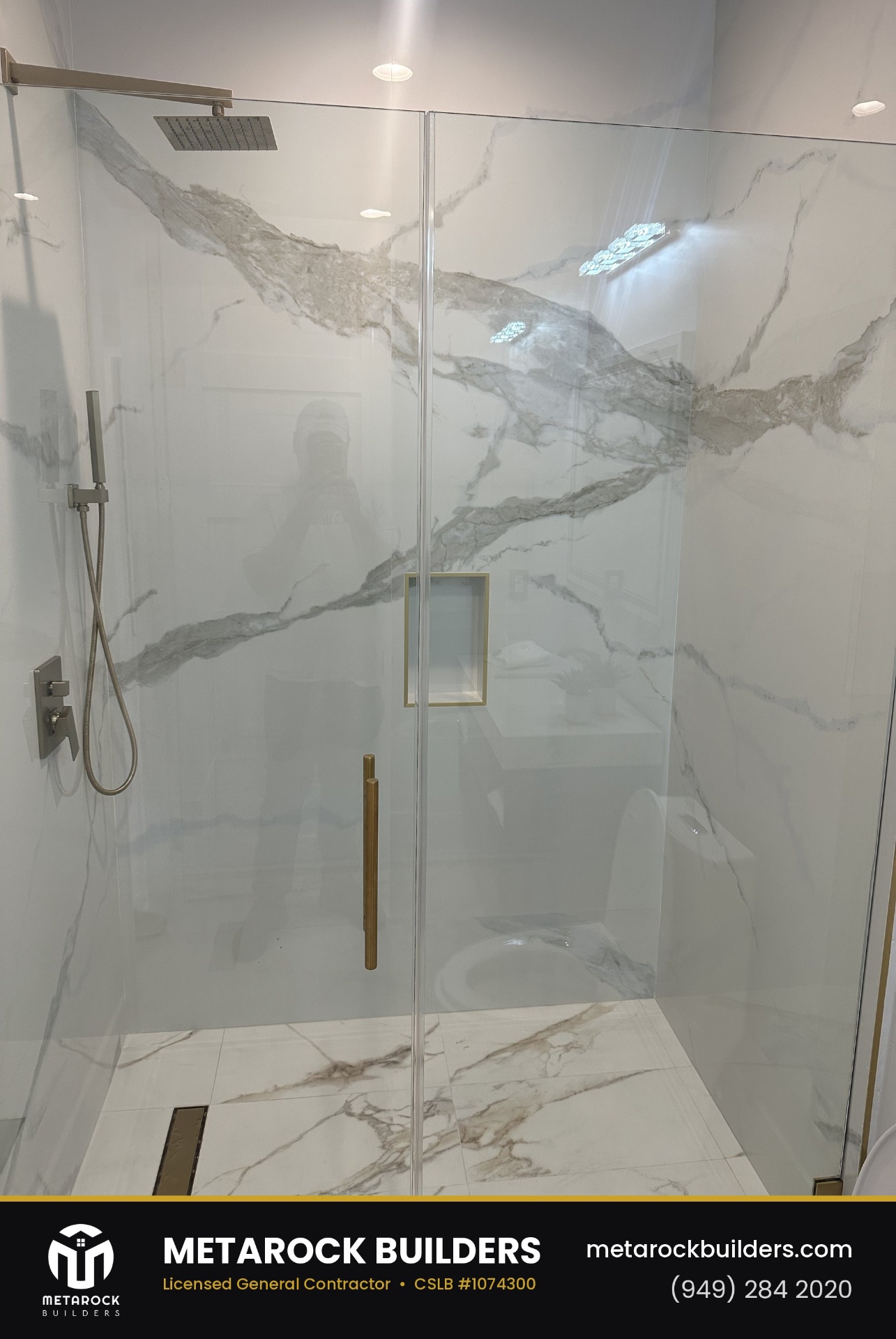 Bathroom remodel in Orange County by Metarock Builders, completed after photo with dramatic book-matched marble slab shower walls, brushed brass hardware, and frameless glass enclosure